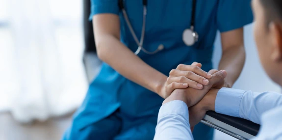 Doctor holding hands of patient